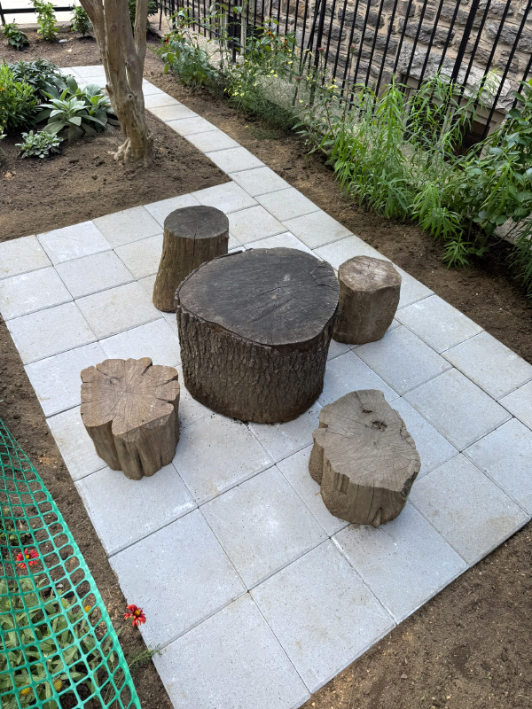 This is where the young Montessori students have meetings, on the Lowe's square gray concrete patio stones.